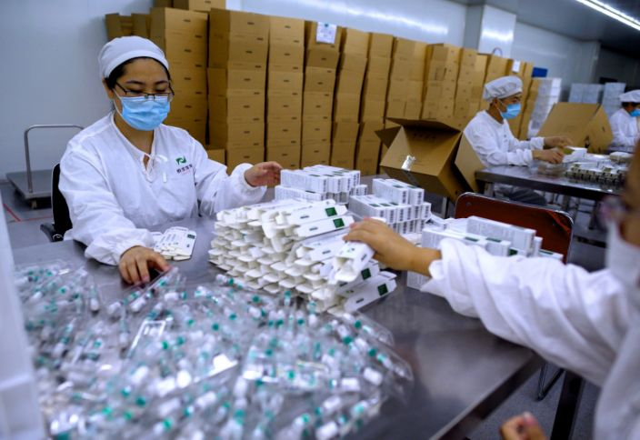 Công nhân đóng gói vắc-xin phòng bệnh dại tại một phòng thí nghiệm thuộc công ty Yisheng Biopharma ở Thẩm Dương (Trung Quốc), nơi các nhà nghiên cứu đang cố gắng phát triển một loại vắc xin ngừa virus COVID-19 - Ảnh: AFP/Getty Images