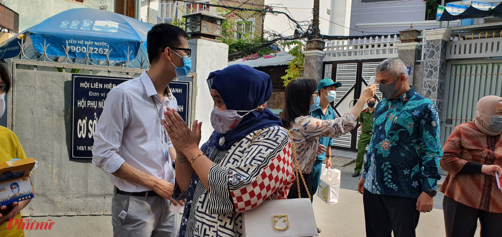 Các thành viên trong Đoàn Bộ Ngoại giao và bè bạn quốc tế đến thăm Mái ấm Bà Chiểu được kiểm tra thân nhiệt và rửa tay sát khuẩn 