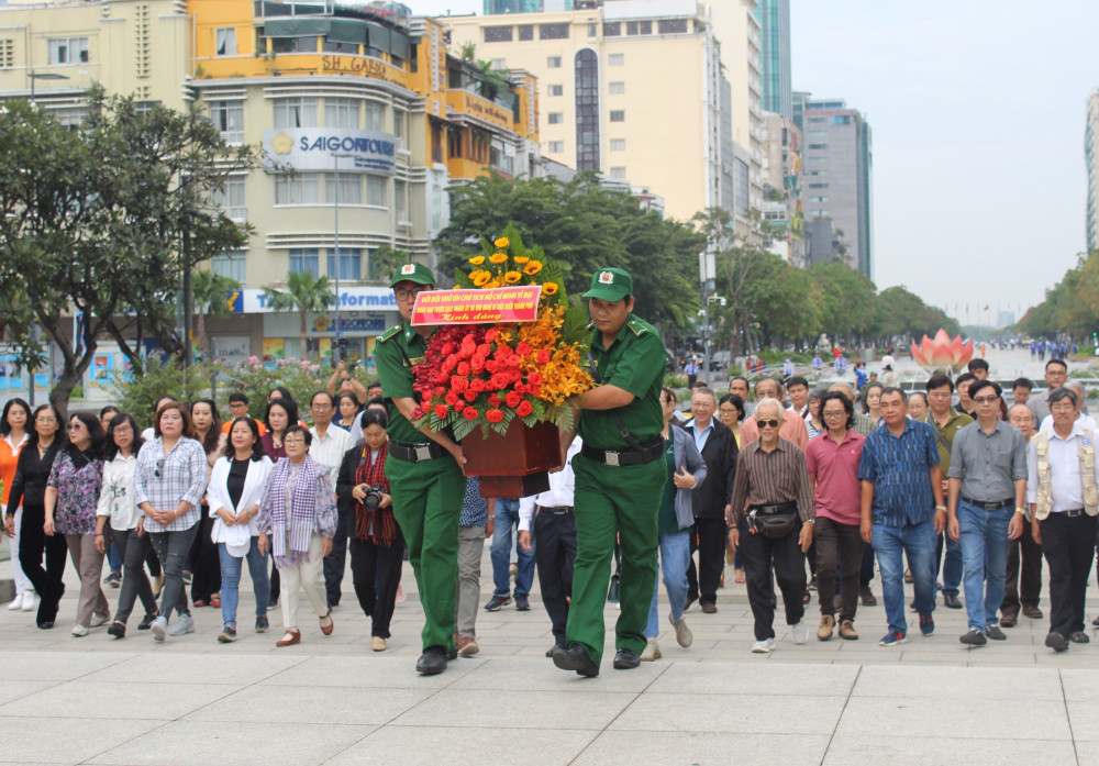 : Các văn nghệ sĩ dâng hoa lên Tượng đài Chủ tịch Hồ Chí Minh (Phố đi bộ Nguyễn Huệ) trước khi bắt đầu chuyến tham quan thực tế.