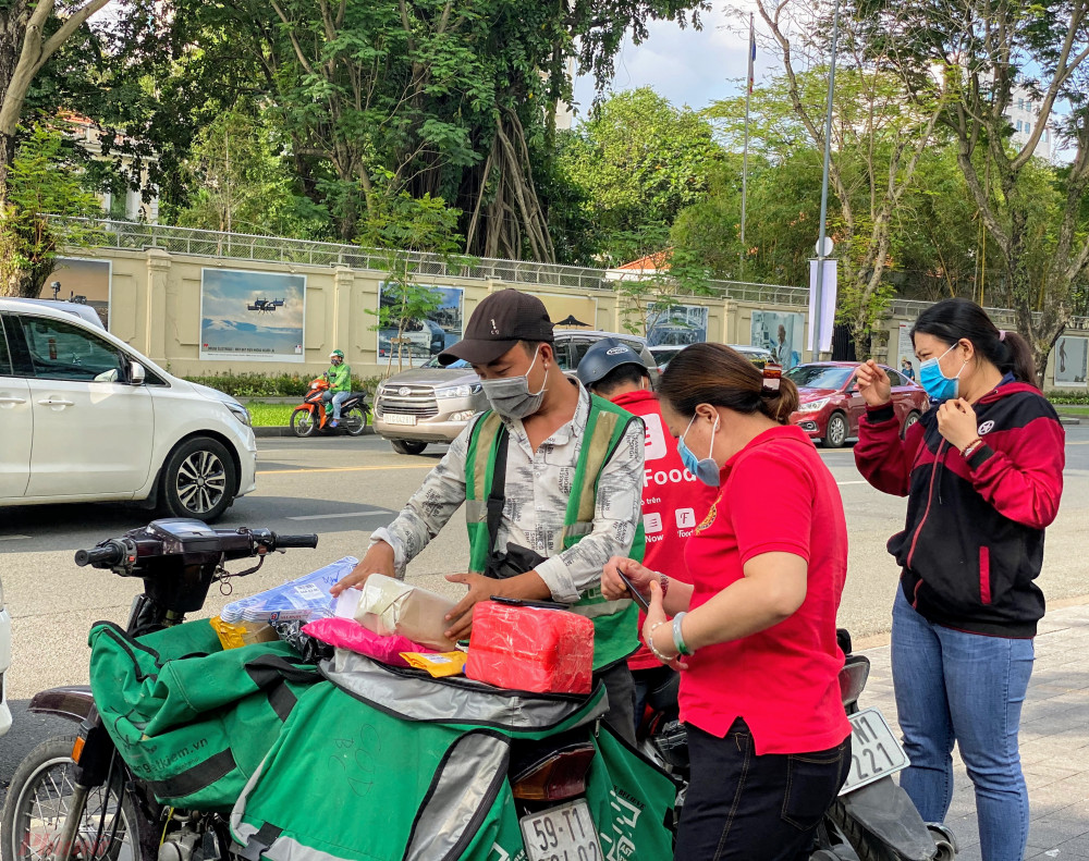 Shipper khác của Giao hàng tiết kiệm bày hàng trên xe máy trong đó có rất nhiều 'đơn hàng 0 đồng', liên tục gọi khách xuống nhận 