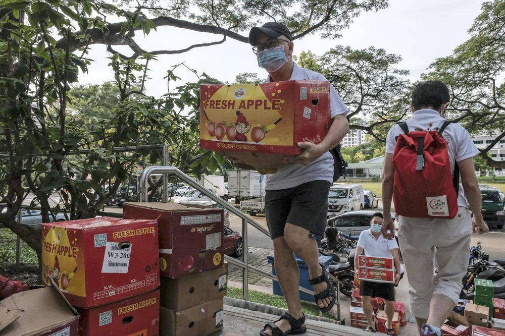 Tình nguyện viên từ tổ chức Keep Hope Alive vận chuyển những thùng trái cây tươi đến một khu nhà ở dành cho người lao động.