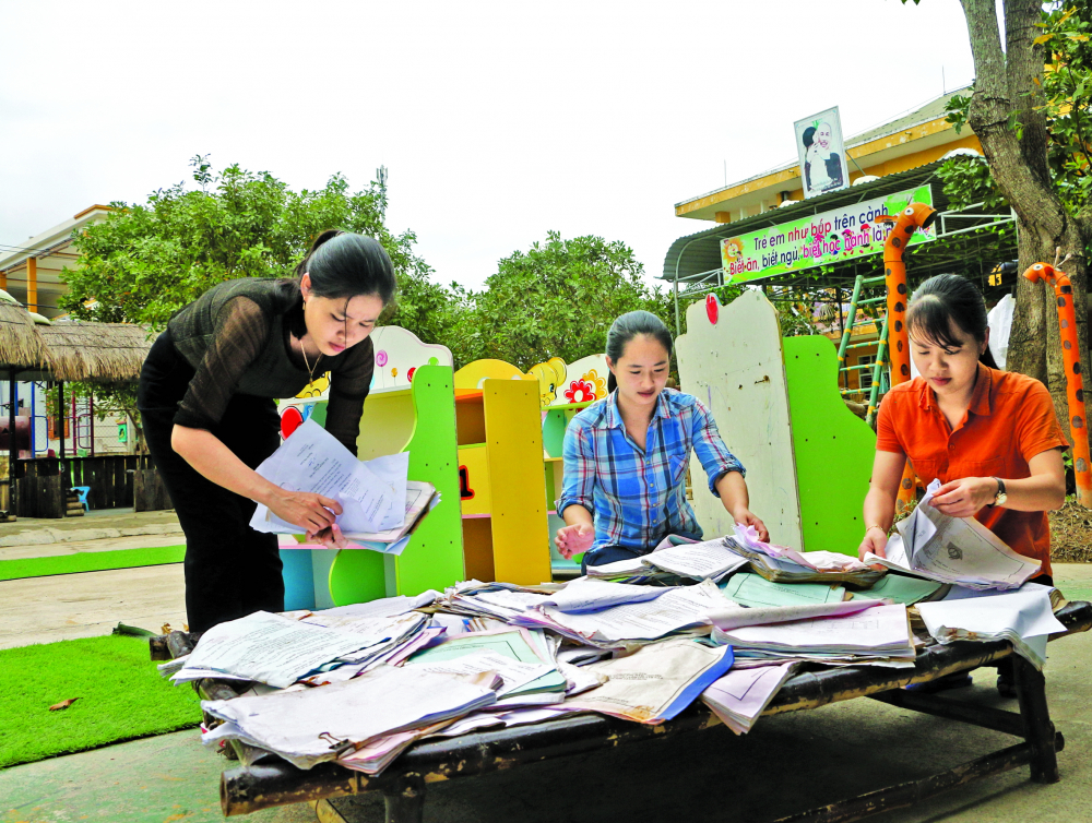 Đến trưa 19/11, cá c cô giáo Trường mầm non Phong Bình 2 vẫn tiếp tục phơi tập, sách do bị ngâm nước lũ dài ngày ẢNH: THUẬN HÓA