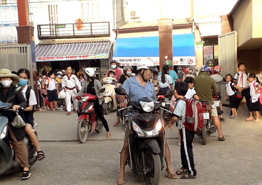 Nhiều phụ huynh vào trường đón con nhưng không đeo khẩu trang - Ảnh: H.N.