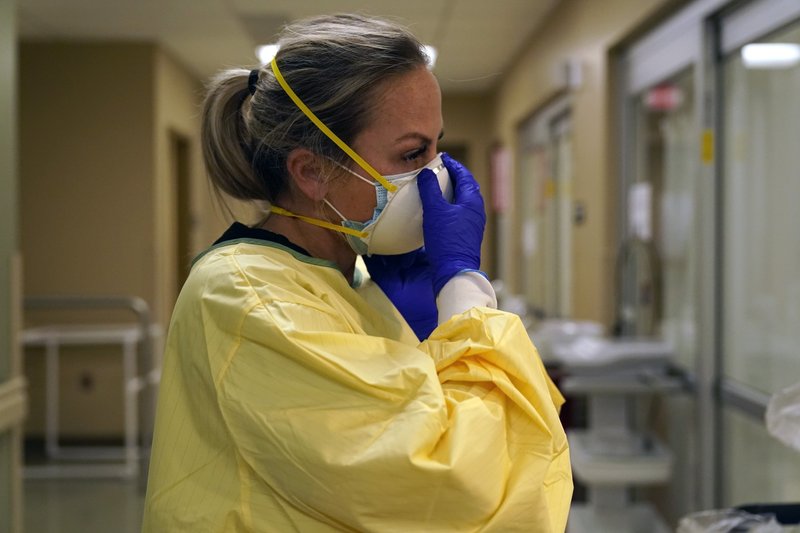 Y tá Chrissie Burkhiser trang bị thiết bị bảo hộ cá nhân khi chuẩn bị điều trị cho một bệnh nhân COVID-19 trong phòng cấp cứu tại Bệnh viện Hạt Scotland ở thành phố Memphis.