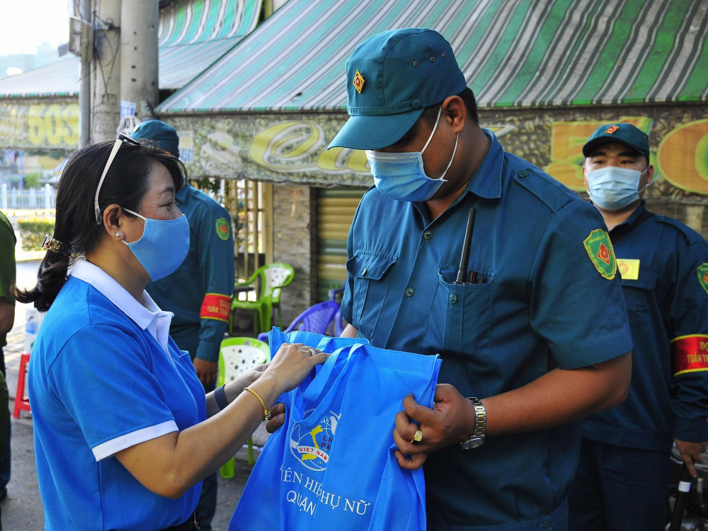 Bà Lương Thanh Trúc- Chủ tịch Hội LHPN Q.6 (trài) trao tặng quà cho chiến sĩ tuyến đầu chống dịch