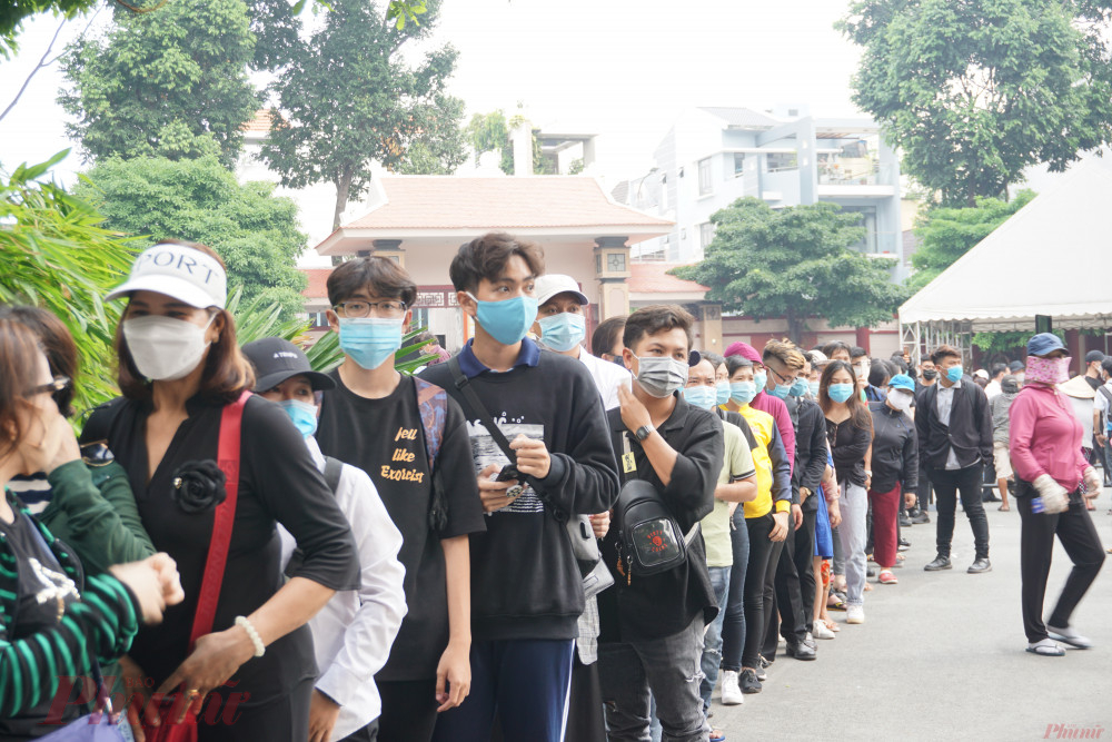 Mọi người xếp hàng trật từ và tuân thủ nghiêm ngặt công tác phòng chống dịch COVID-19: đeo khẩu trang và rửa tay sát trùng.