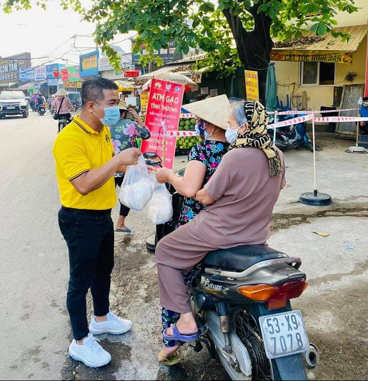 Thành viên ban tổ chức hỗ trợ bà con nhận gạo. 