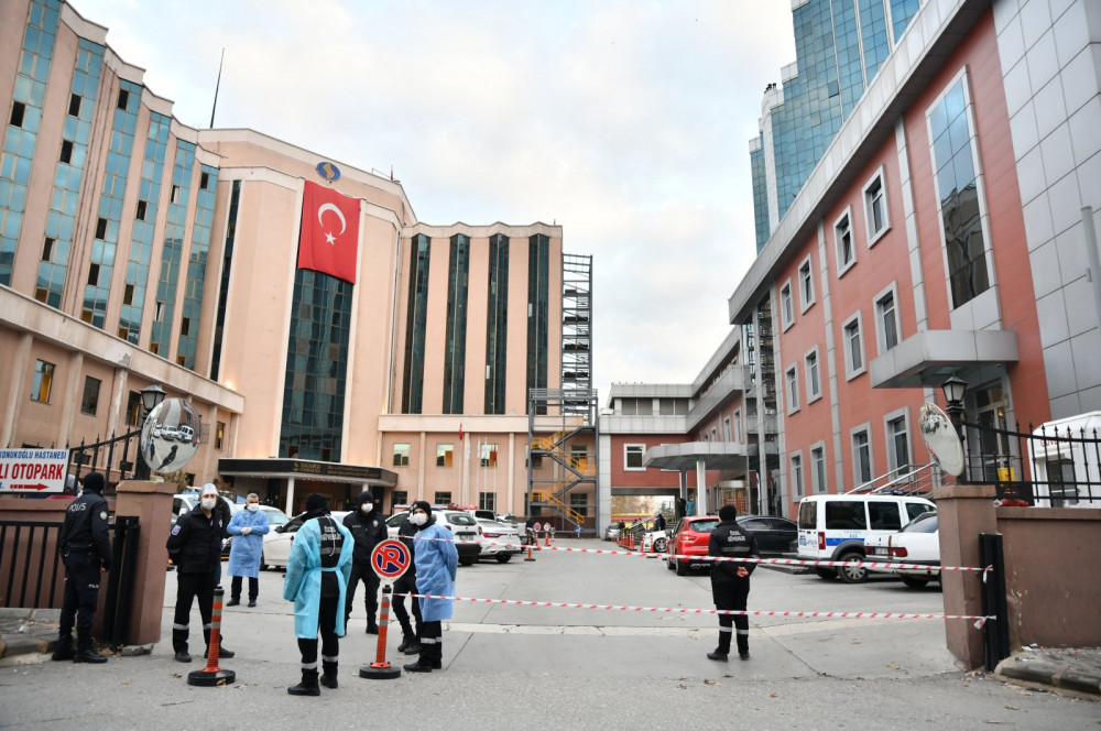 Nhân viên an ninh đứng trước bệnh viện Đại học Sanko sau vụ hỏa hoạn.