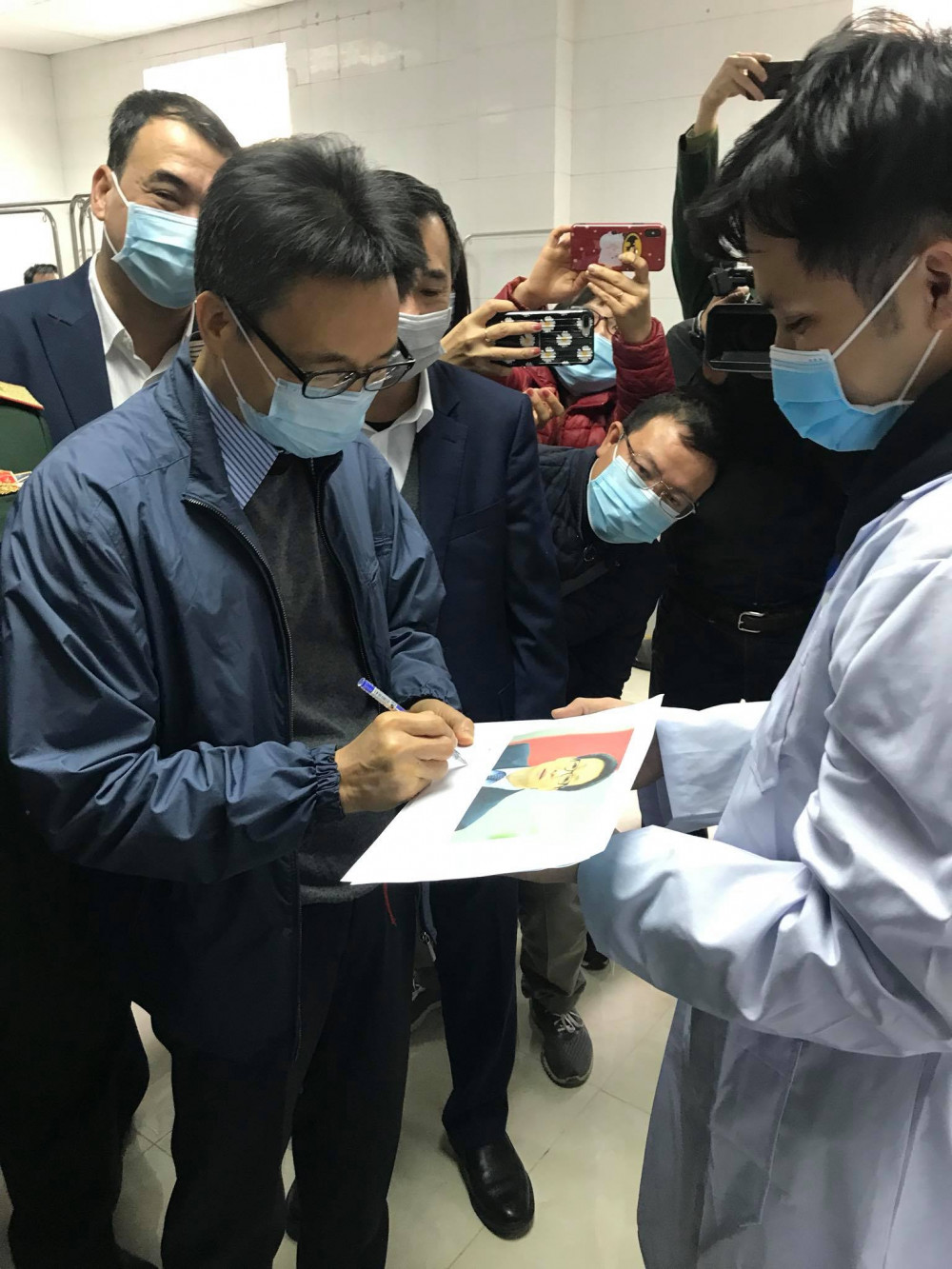 Phó Thủ tướng xúc động ký tên vào bức hình của một nam tình nguyện viên tham gia chương trình
