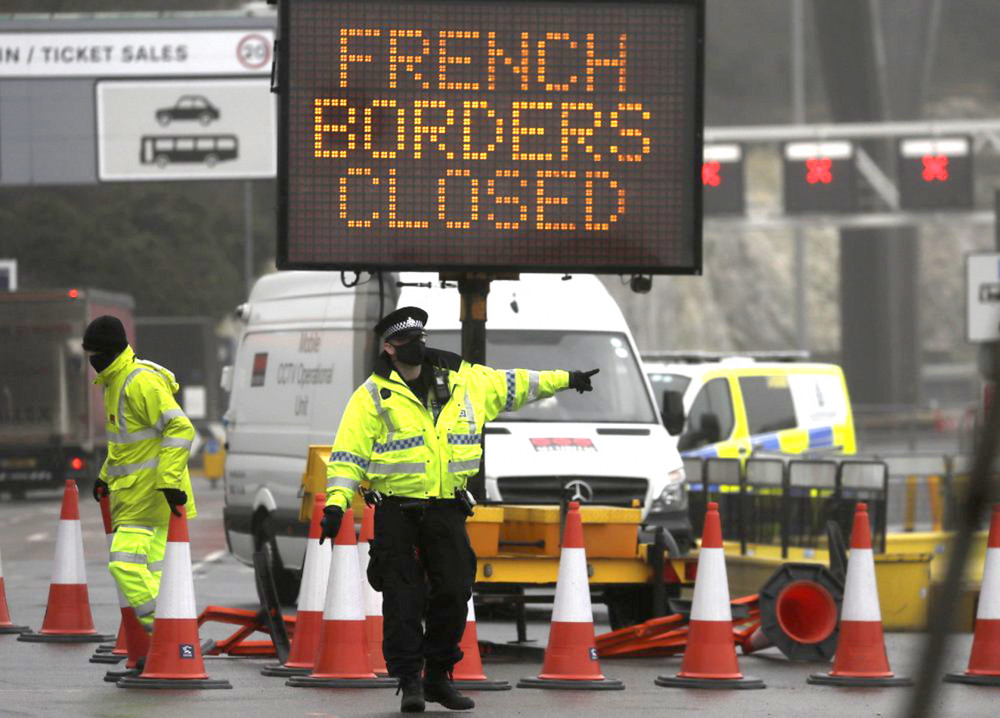 Một sĩ quan cảnh sát hướng dẫn giao thông tại lối vào bến phà đã đóng cửa ở Dover, Anh - Ảnh: AP