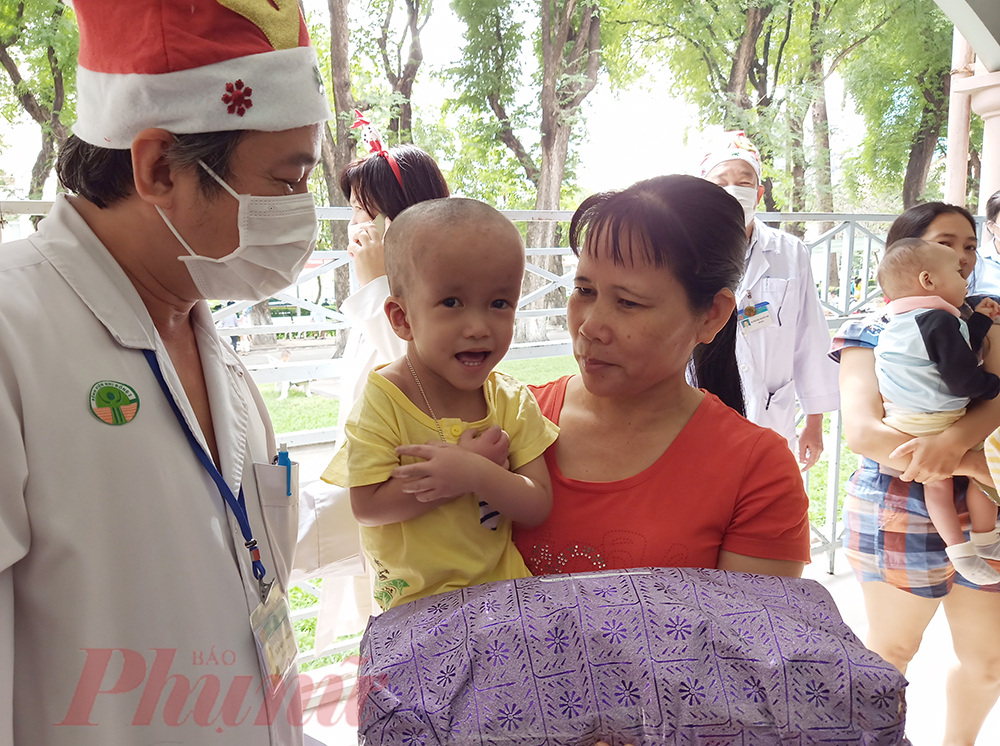 Bé Lê Minh Phong đang điều trị tại khoa Tim Mạch ngoan ngoãn khoanh tay ạ bác khi được tặng quà.