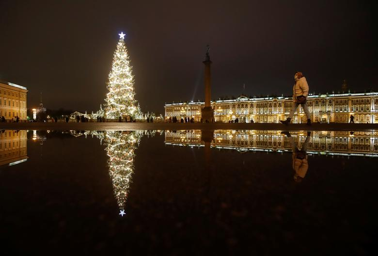 Một người phụ nữ đi bộ gần cây thông Noel ở Quảng trường Cung điện, trung tâm thành phố Saint Petersburg, Nga