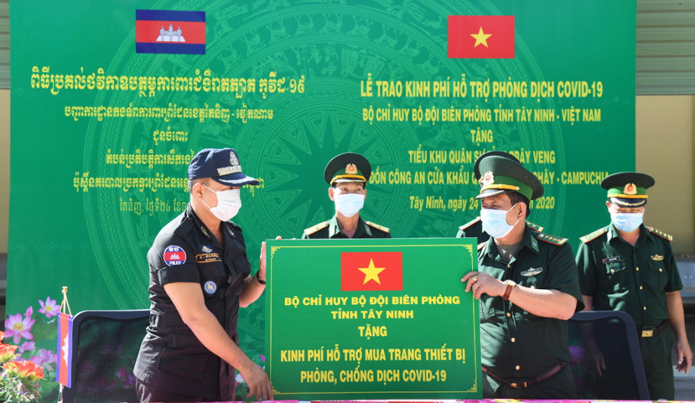 Đại tá Lê Hồng Vương (phải) trao bảng hỗ trợ tượng trưng cho đại tá Bun Bê (trái) 