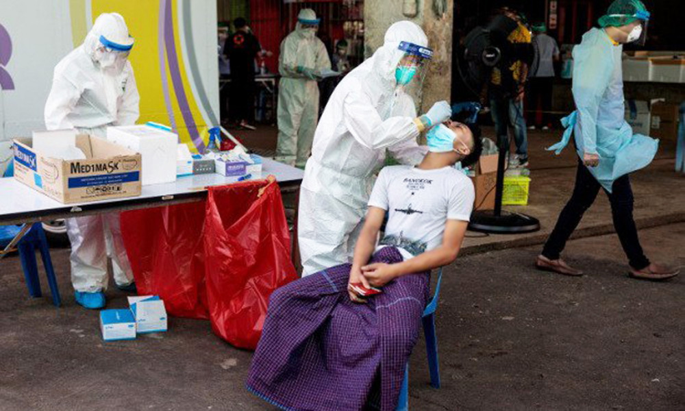Nhân viên y tế lấy mẫu dịch hầu họng để kiểm tra COVID-19 tại chợ hải sản tỉnh Samut Sakhon, Thái Lan - Ảnh: AFP