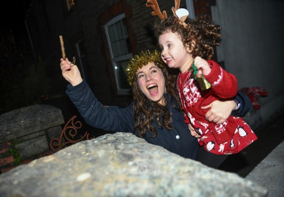 Lillian Joy, ba tuổi và mẹ của cô, Bethan, rung chuông để cổ vũ lễ hội bên ngoài nhà của họ ở Swansea, miền nam xứ Wales. Trước tình hình dịch bệnh diễn tiến nghiêm trọng, chính phủ ANh đã áp đặt các biện pháp hạn chế gắt gao, buộc các gia đình phải đón ngày lễ tại nhà.