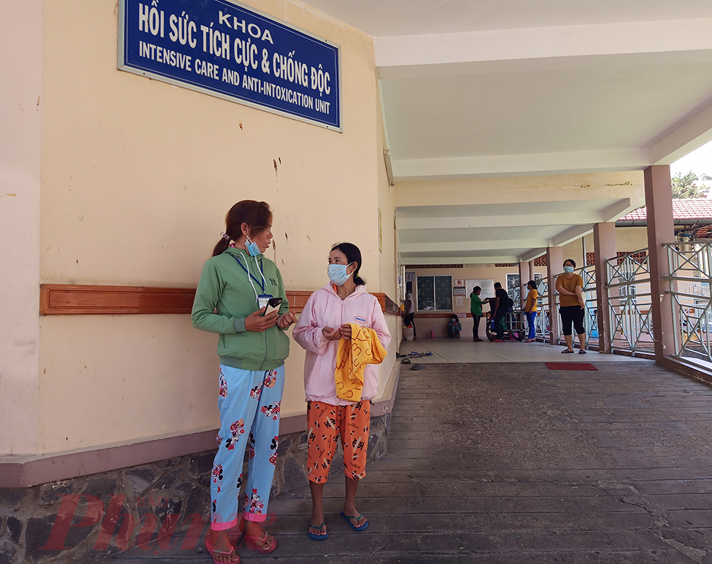 Chị K'Ngô (bên phải) cầm chiếc khăn mới mua, cứ đứng ở khoa Hồi sức tích cực - Chống độc để đợi thăm con
