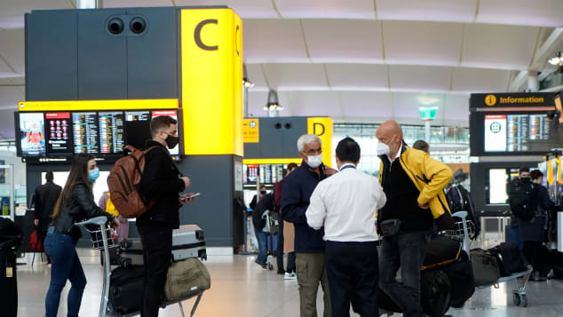 Hành khách đeo khẩu trang chờ đợi check-in tại sân bay Heathrow ở London ngày 21/12, khi hàng loạt quốc gia trên thế giới bắt đầu chặn đường bay từ Anh