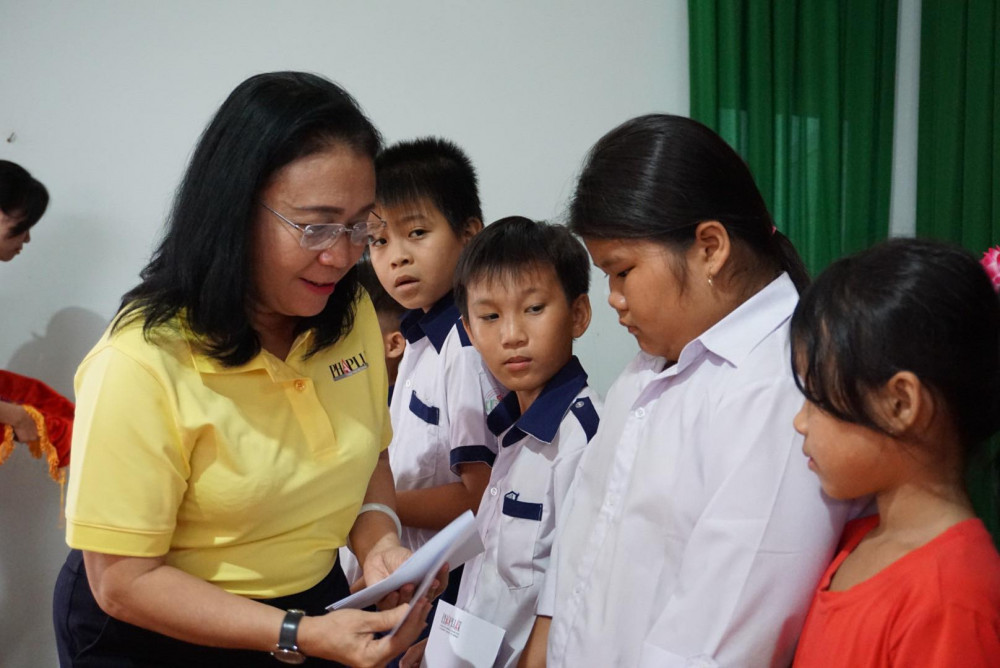 Bà Cát Thị Kim Xuân - Phó Tổng biên tập Báo Pháp luật TPHCM trao học bổng cho các em học sinh 