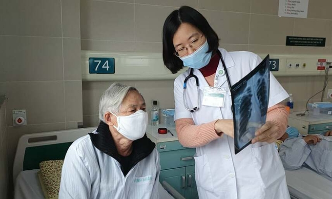 Bác sĩ Thủy kiểm tra phim chụp phổi cho bệnh nhân trước khi xuất viện.