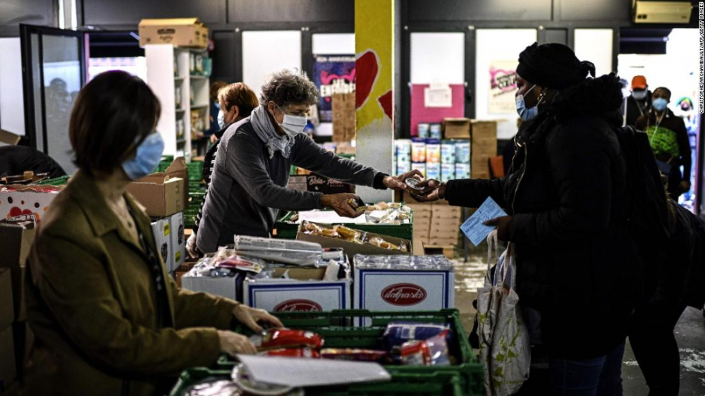 Một tình nguyện viên tại ngân hàng thực phẩm Restos du Coeur ở Paris phát thực phẩm hỗ trọ hồi tháng 10 - Ảnh: CNN/AFP