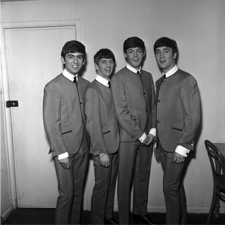 Ban nhạc The Beatle diện thiết kế áo khoác không cổ của Cardin năm 1963. Cardin là nhà tạo mẫu đi đầu trong nỗ lực thúc đẩy sự phát triển của ngành thời trang nam cao cấp. (Ảnh: Getty)