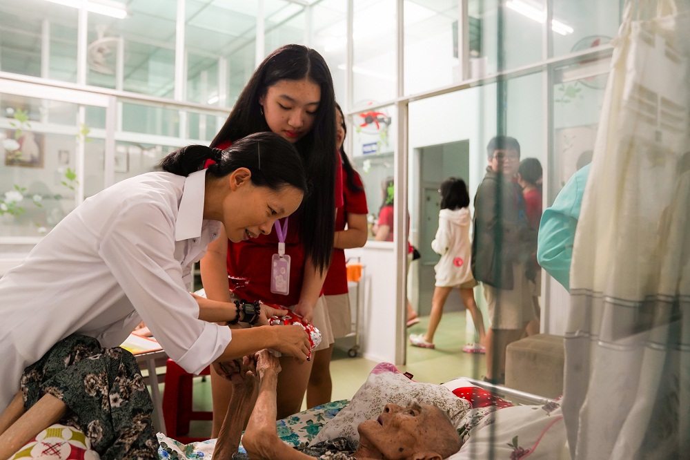 Các bạn học sinh tại Royal School hỏi thăm các cụ bà tại Viện dưỡng lão Vinh Sơn. Ảnh: Royal School cung cấp