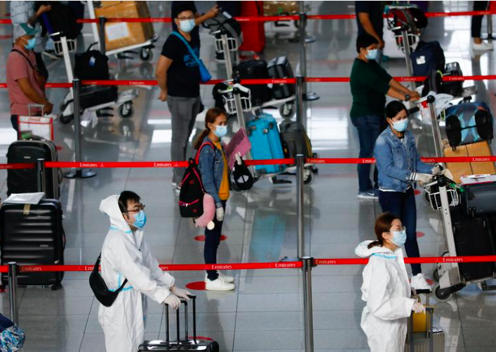 Hành khách đeo thiết bị bảo vệ cá nhân để bảo vệ chống lại bệnh coronavirus (COVID-19) xếp hàng tại quầy làm thủ tục của hãng hàng không Emirates, ở Sân bay Quốc tế Ninoy Aquino ở Thành phố Pasay, Metro Manila, Philippines, ngày 9 tháng 7 năm 2020. REUTERS / Eloisa Lopez