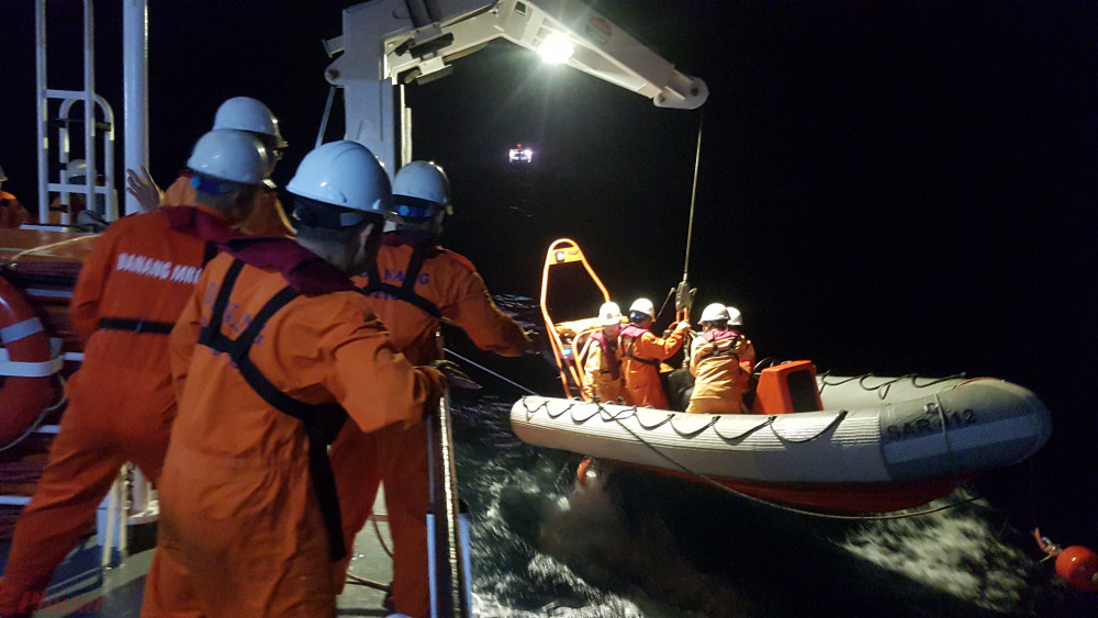Xuồng cứu nạn rời tàu tiếp cận tàu cá đưa ngư dân về SAR 412