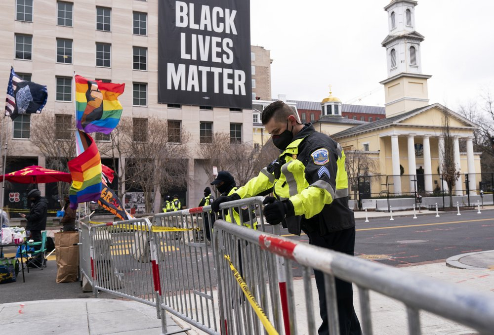 Một sĩ quan Cảnh sát Metropolitan kiểm tra hàng rào ngăn người đi bộ ra khỏi khu vực của Black Lives Matter Plaza