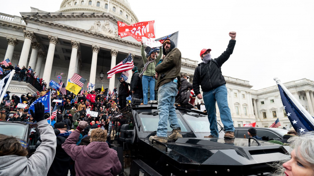 Những người ủng hộ ông Trump đứng trên một chiếc xe bọc thép của cảnh sát