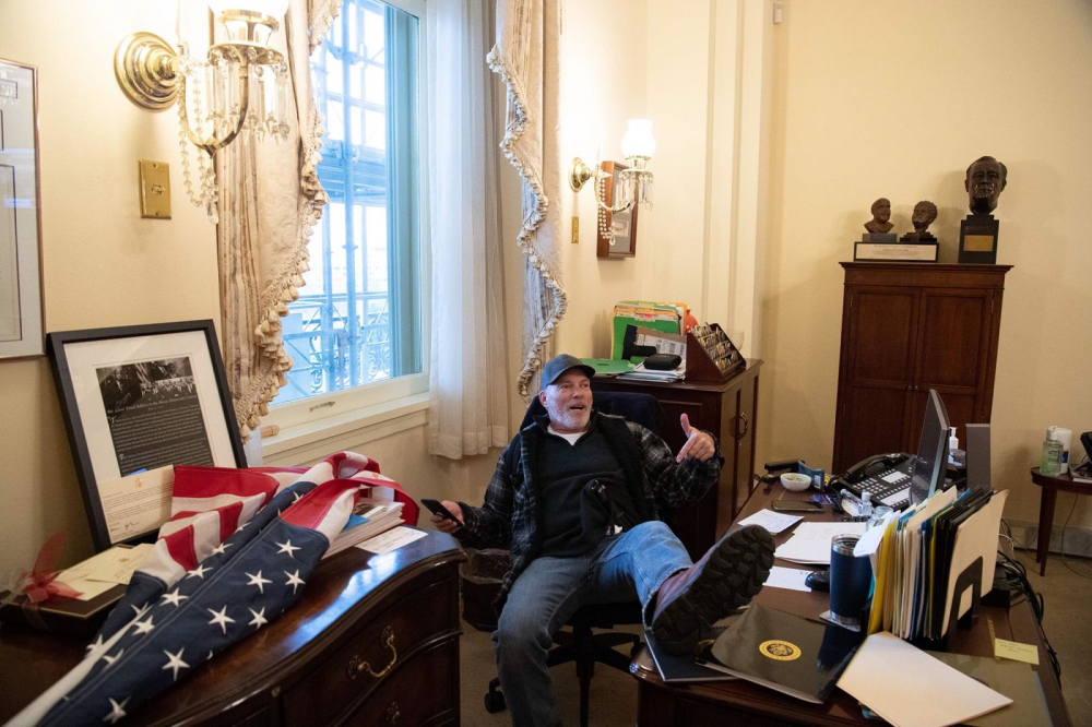 Một người ủng hộ ông Trump ngồi bên trong văn phòng của Chủ tịch Hạ viện Nancy Pelosi sau khi đột nhập Điện Capitol