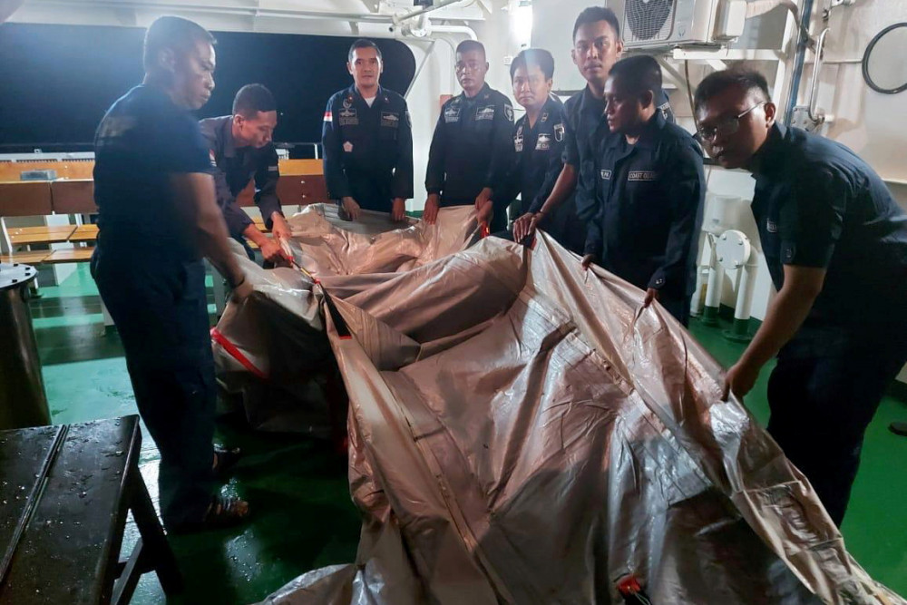Các nhân viên tìm kiếm và cứu hộ Indonesia kiểm tra một chiếc túi có mảnh vỡ được cho là của chiếc máy bay Sriwijaya Air mất tích, tại cảng Tanjung Priok ở Jakarta, Indonesia, rạng sáng 10/1