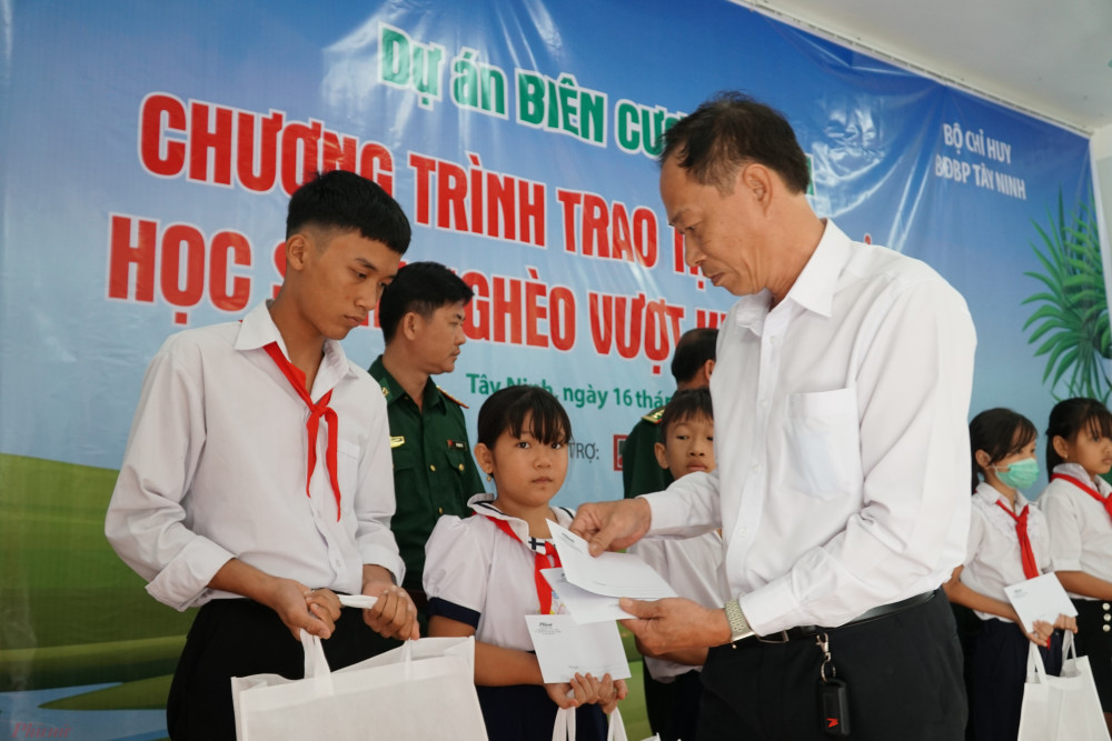 Ông Hồ Văn Đụng đại diện nhà tài trợ Agribank trao học bổng cho các em học sinh.