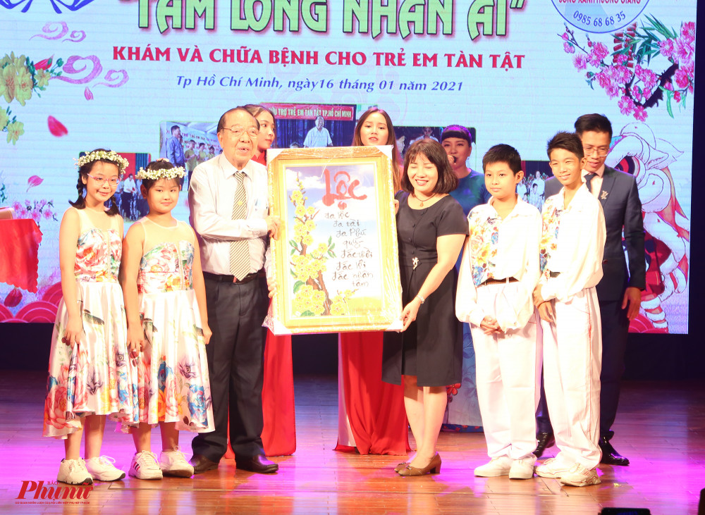 Ông Nguyễn Văn Chí (chủ tịch Hội cứu trợ trẻ em tàn tật TPHCM) nhận bức tranh kết cườm của các em từ trường Hy Vọng.