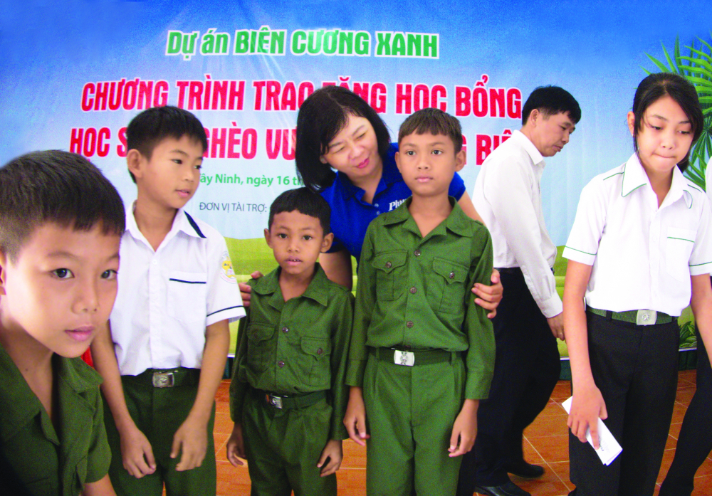 Bà Lý Việt Trung - Tổ ng biên tậ p Bá o Phụ Nữ TP.HCM - trao học bổng cho các em học sinh khó khăn ở vùng biên ẢNH: PHÙ NG HUY