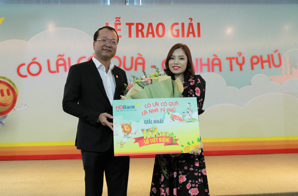 Ông Trần Quốc Anh - Giám đốc khối KHCN HDBank chúc mừng khách hàng Đinh Thị Tuyết Nhung đã may mắn trúng giải Nhất trị giá tỷ đồng chương trình ưu đãi hè 2020. Ảnh: HDBank
