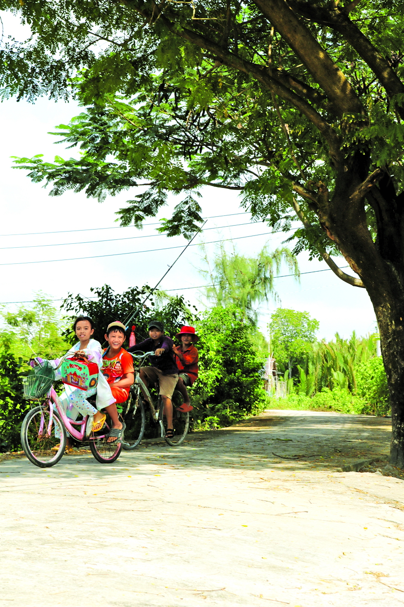Bọn trẻ đạp xe trên đường làng  đi câu cá vào dịp cuối tuần - Ảnh: Tiểu Quyên