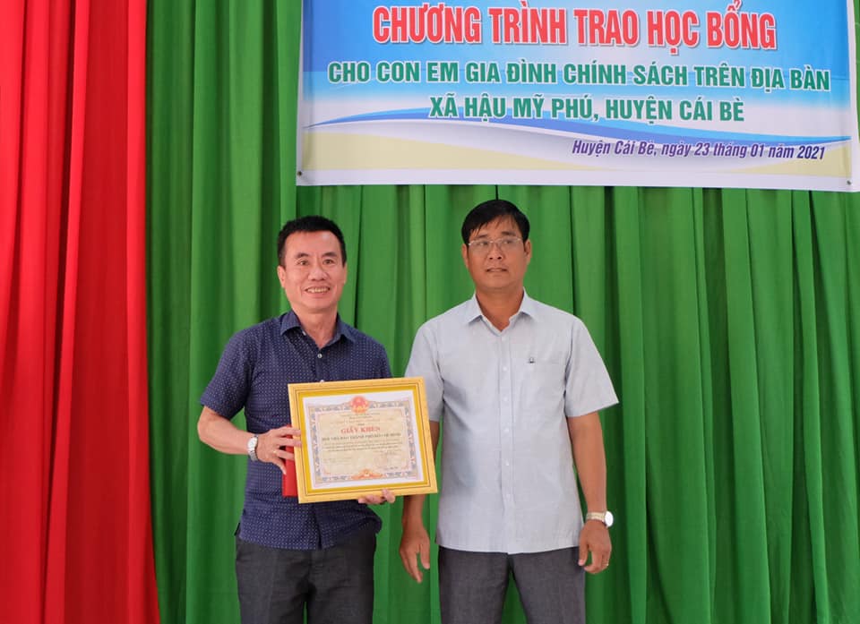 Ông Bùi Công Thành - Bí thư Đảng ủy, Chủ tịch HĐND xã Hậu Mỹ Phú tặng hoa và giấy khen cho Hội Nhà Báo TPHCM.