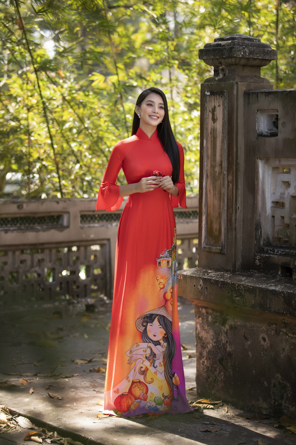 Hoa hậu Tiểu Vy cũng diện áo dài sắc đỏ nhưng với dáng dài thướt tha hiện đại. 