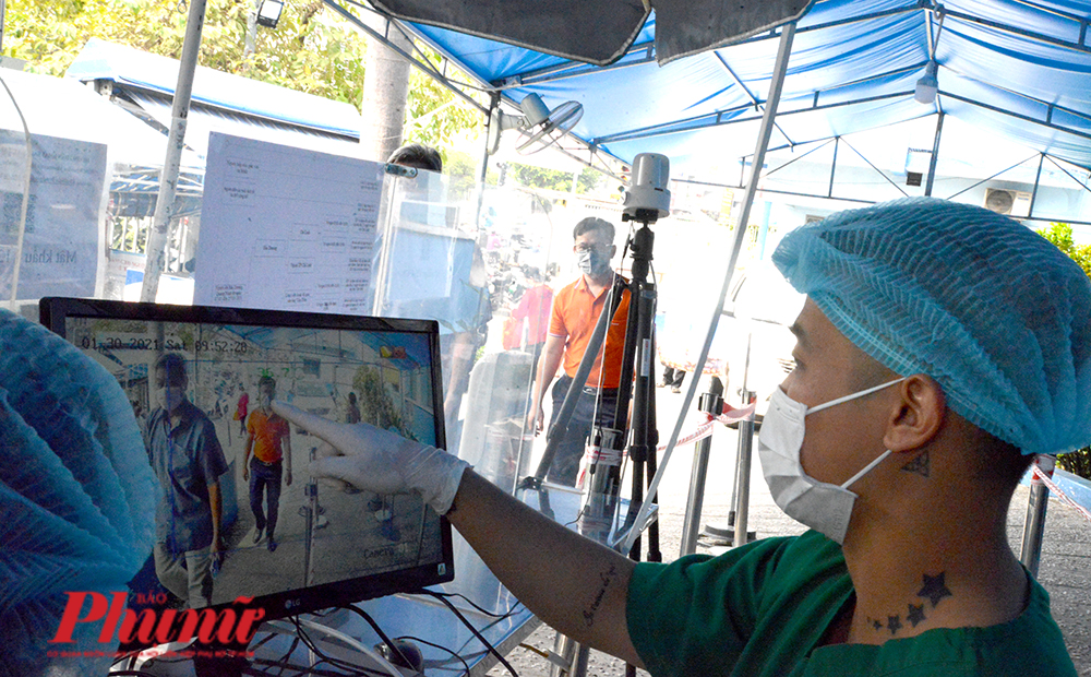Kiểm soát người ra vào tại Bệnh viện nhân dân Gia Định bằng máy đo thân nhiệt từ xa. Ảnh: Hiếu Nguyễn