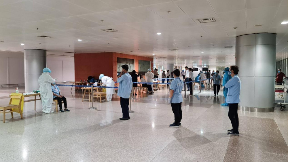 Nhân viên tại sân bay Tân Sơn Nhất xếp hàng đợi lấy mẫu xét nghiệm COVID-19, ảnh HCDC