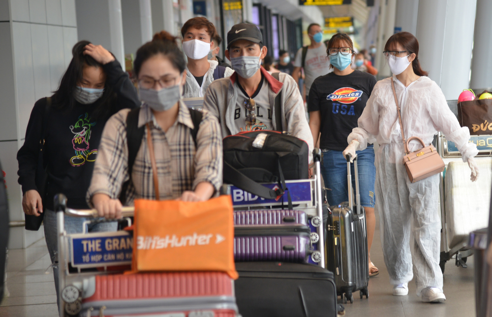 Người dân về quê luôn thủ quy định chống dịch tại sân bay. Nhiều hành khách còn tự trang bị quần áo bảo hộ khi vào cảng làm thủ tục bay.