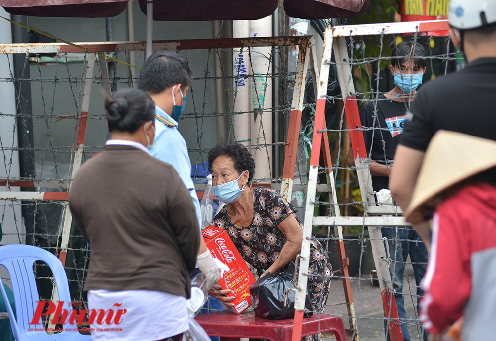 Người dân trong khu phong tỏa ở quận 1, TPHCM nhận thùng nước ngọt để ăn Tết. 