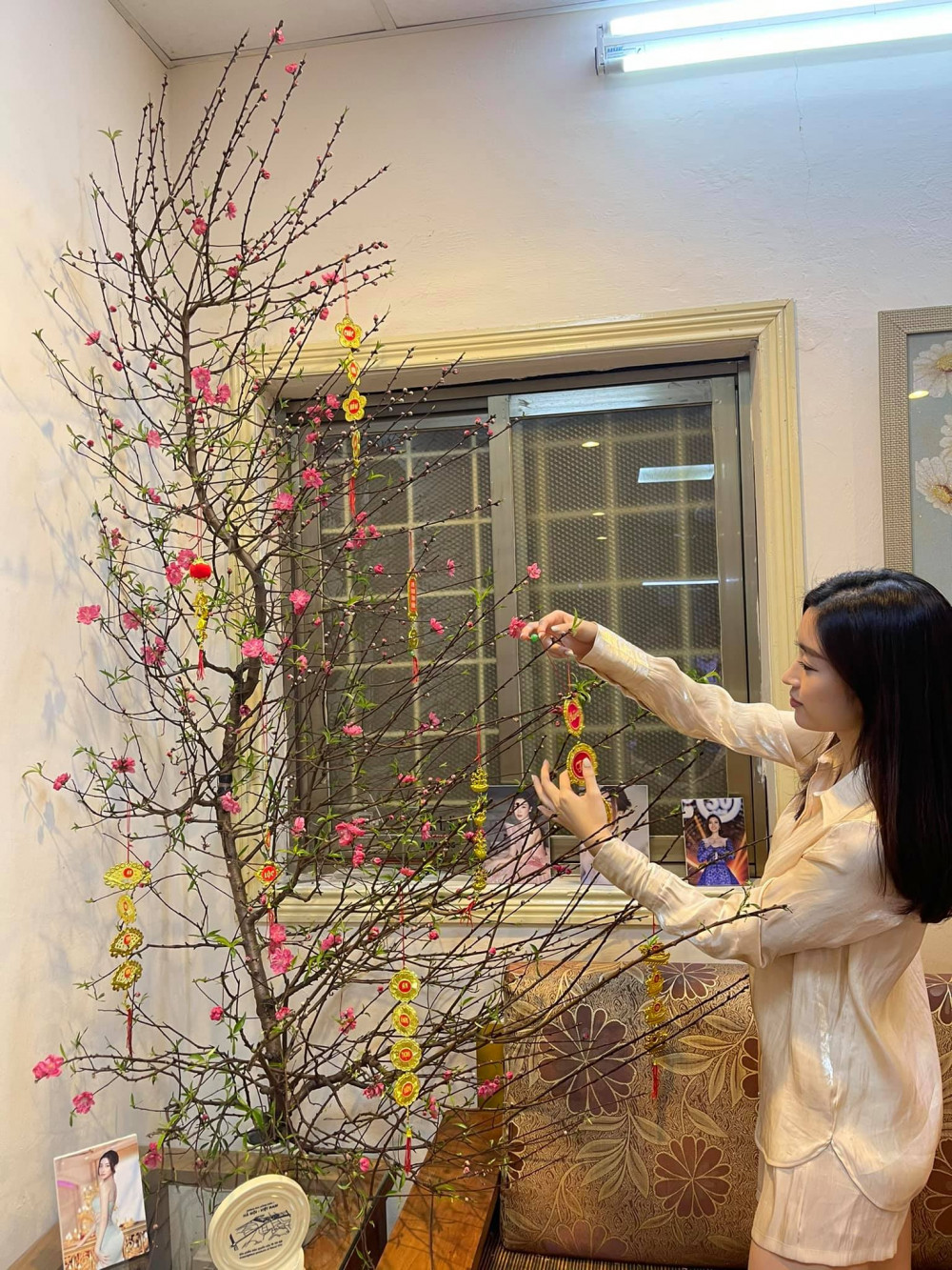 Hoa hậu Đỗ Mỹ Linh chăm chút lại cây hoa đào trong thời gian chờ giao thừa. Trước đó, người đẹp còn khoe phụ gia đình chuẩn bị mâm cơm cúng cuối năm.