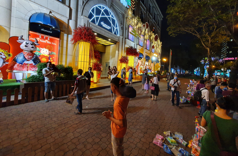 Thay vì đến bờ sông Sài Gòn và đường hoa du xuân như mọi năm, người dân đến các trung tâm thương mại có trang trí lộng lẫy chụp ảnh 