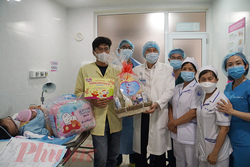 TS.BS Lê Quang Thanh - Giám đốc Bệnh viện Từ Dũ TPHCM cùng các y, bác sĩ trong ê-kíp trực tặng quà chúc mừng gia đình chị Trúc