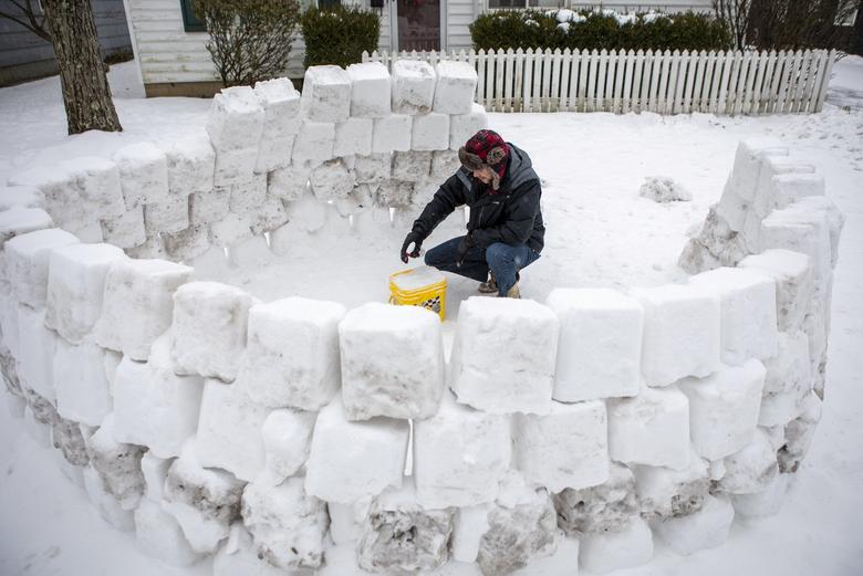 Jeremy Seidt (44 tuổi, Columbus, Ohio) xúc tuyết vào chiếc thùng, tạo thành những viên hình vuông rồi xây thành lều tuyết.