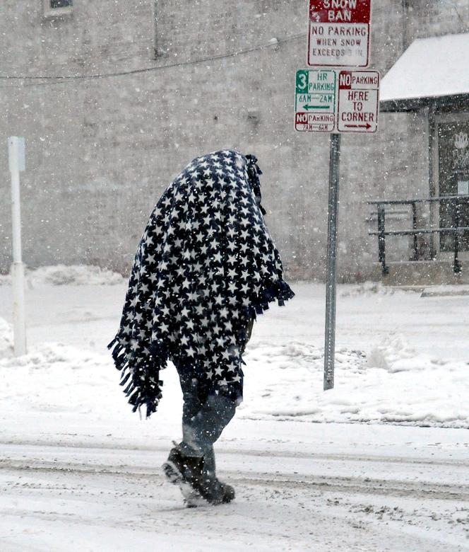 Một người đàn ông ở Wooster, Ohio trùm kín mít khi di chuyển trên đường phố phủ đầy tuyết.