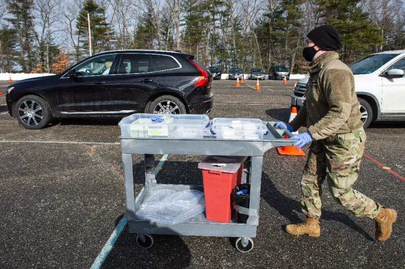 Một binh sĩ Vệ binh Quốc gia Hoa Kỳ đẩy xe các ống tiêm chứa vắc-xin Moderna ngừa COVID-19 tại một trung tâm tiêm chủng ở Londonderry, tiểu bang New Hampshire - Ảnh: AFP