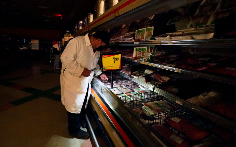 Một người mua hàng ở Dallas dùng điện thoại tìm kiếm sản phẩm tại một siêu thị